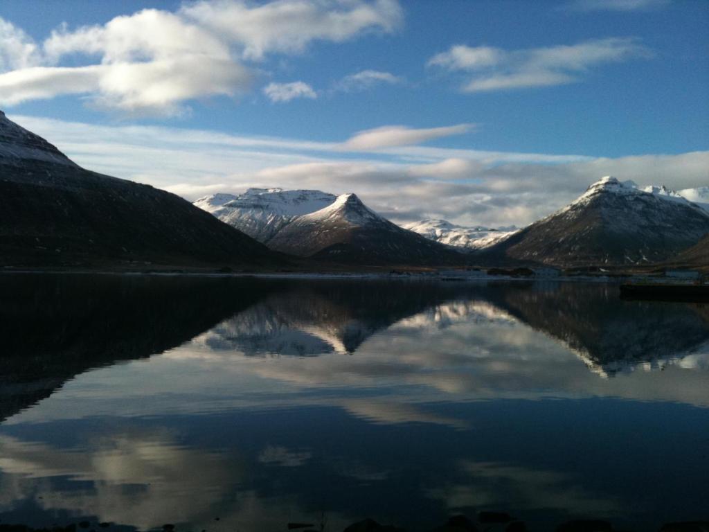 a reflection of mountains in a body of water at Studio 22 in Reyðarfjörður