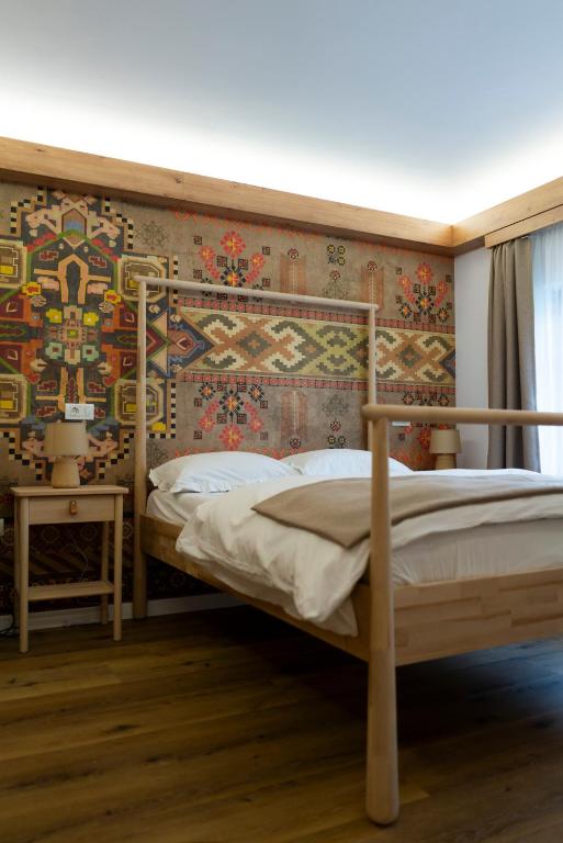 a bedroom with a bed and a wall with a mural at MonteRai in Văliug