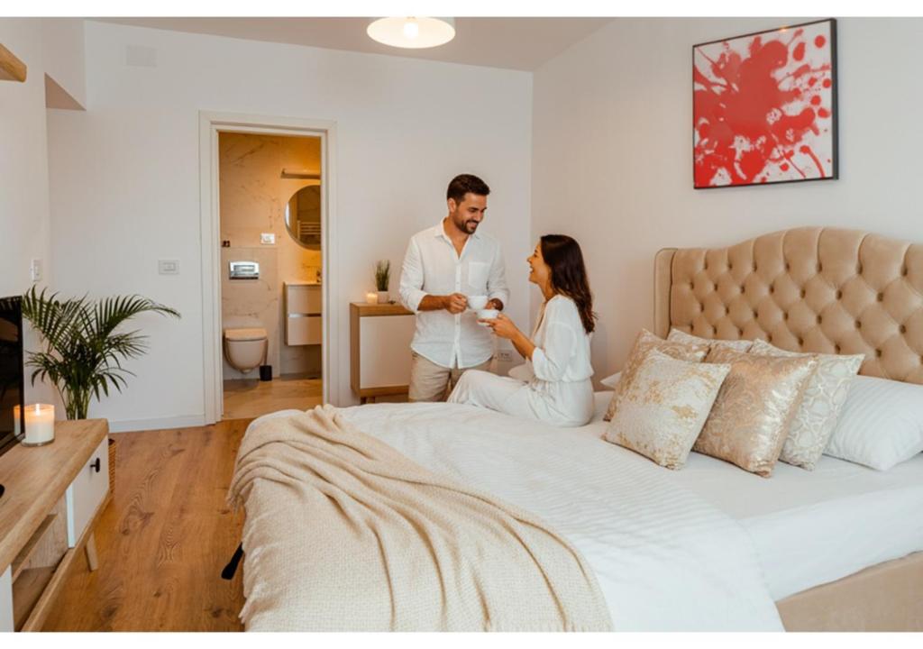 un homme et une femme assis sur un lit dans l'établissement Ivory by Blvd 25B4 - Premium Studio with Garden View, à Bucarest