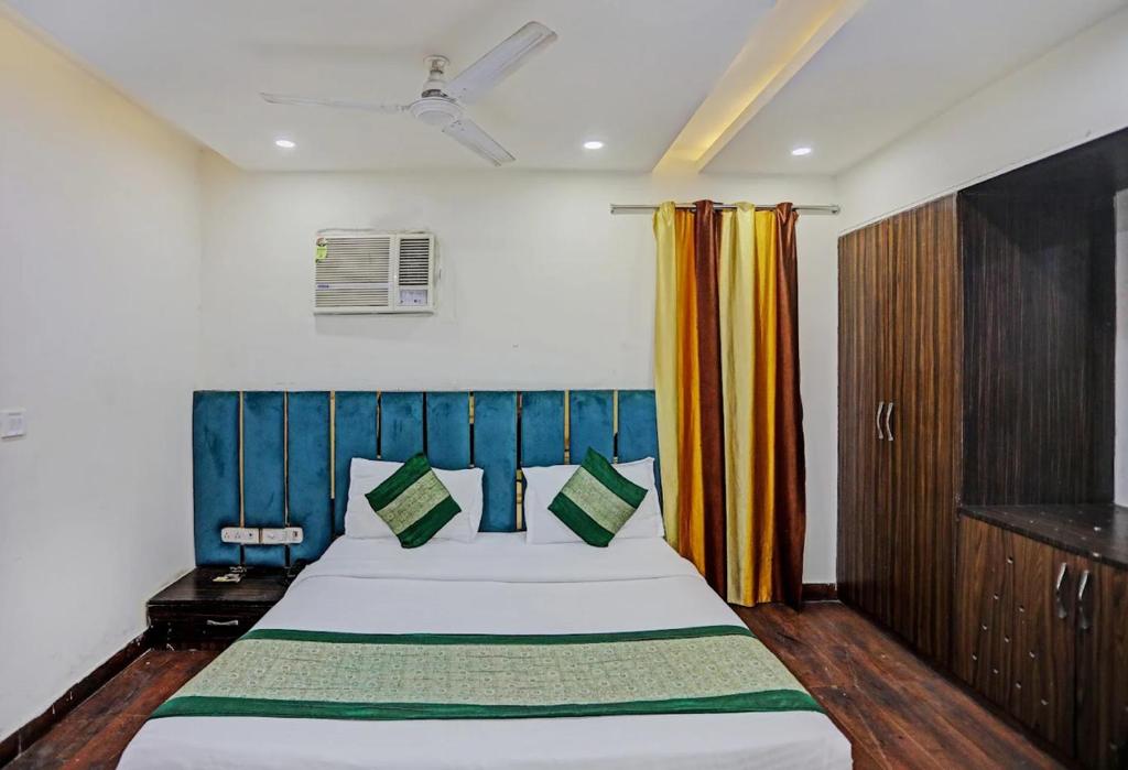a bedroom with a large bed with a blue headboard at Hotel Sehej Continental At Karol Bagh in New Delhi
