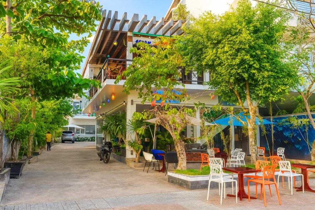 a cafe with tables and chairs in front of a building at Đại An Hotel Bến Tre in Ben Tre