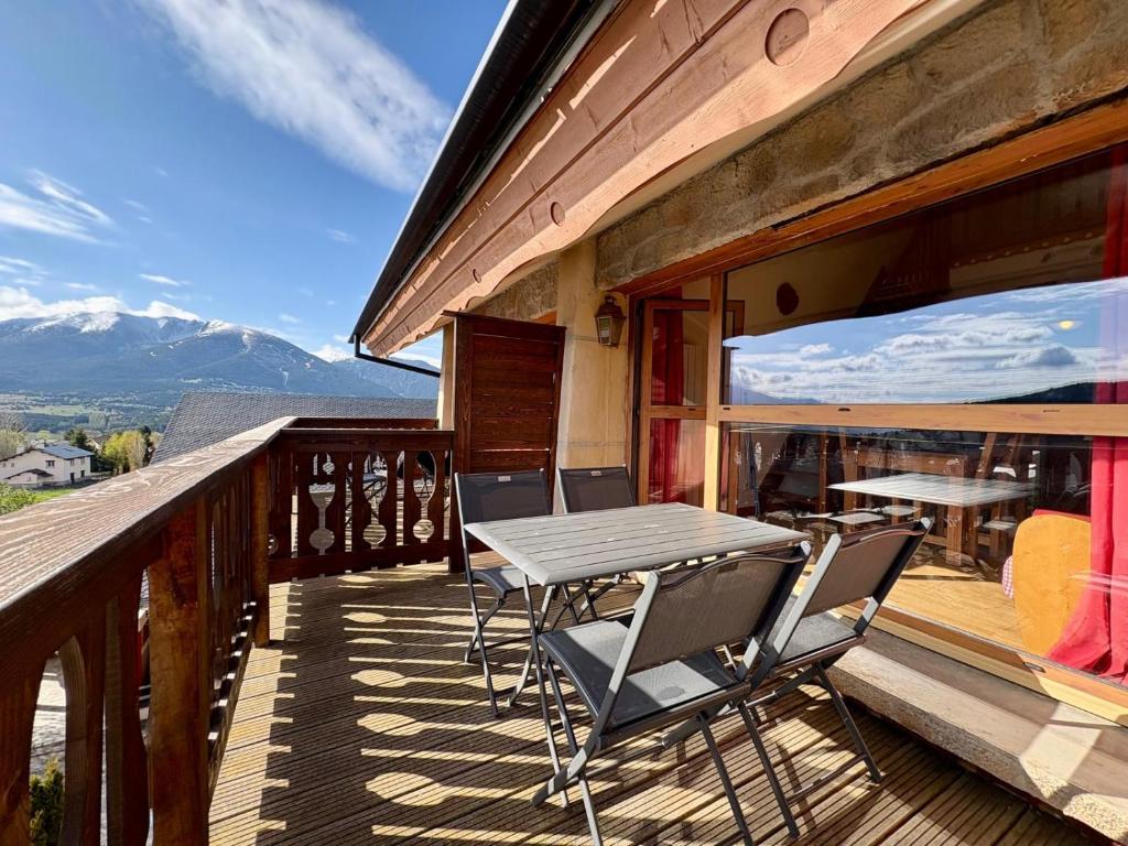 a wooden balcony with a table and chairs on it at Appartement cosy T2 Duplex in Bolquere Pyrenees 2000