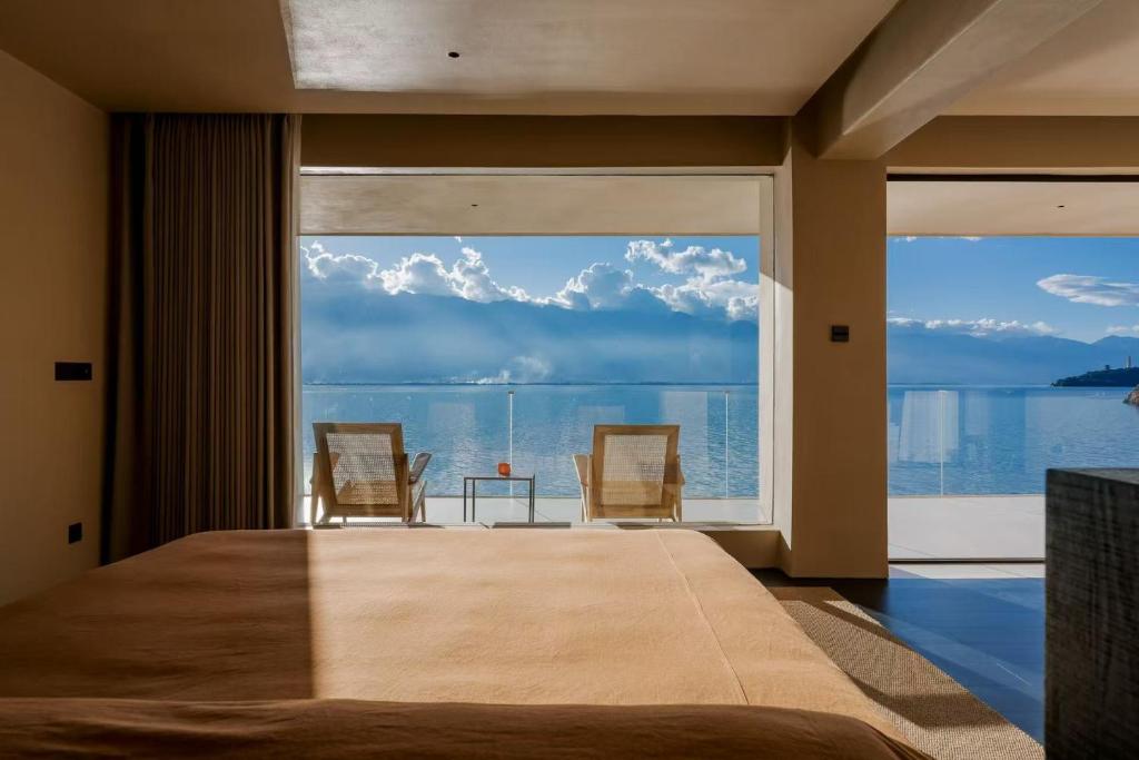 a bedroom with a large window with a view of the water at Dali Rushi Jiuxi Sea View Holiday Inn in Dali Airport