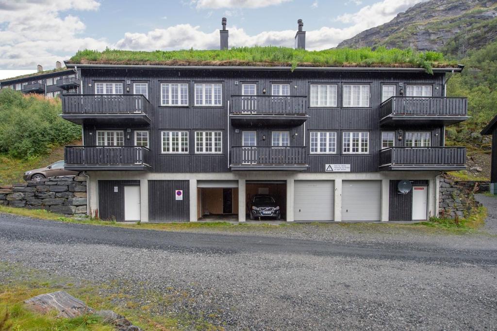 a large building with a grass roof on top of it at Pleasant mountain apartment in Røldal, with a view in Håra