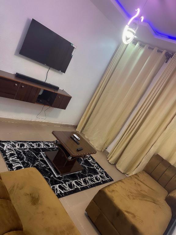 a living room with a flat screen tv and a couch at OA luxury apartment 