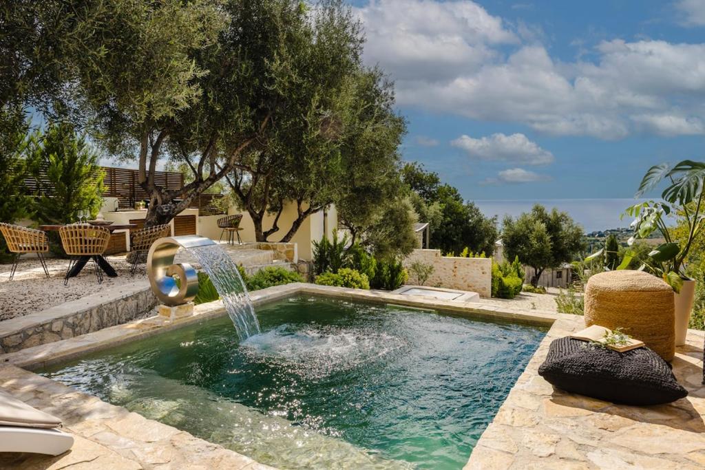 een zwembad met een fontein in een tuin bij Vinothea Vista in Kefallonia