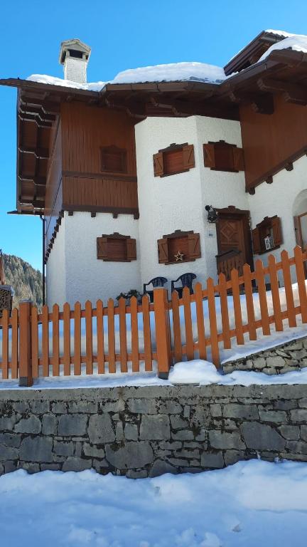 a house with a fence in the snow at Cesira in Mareson