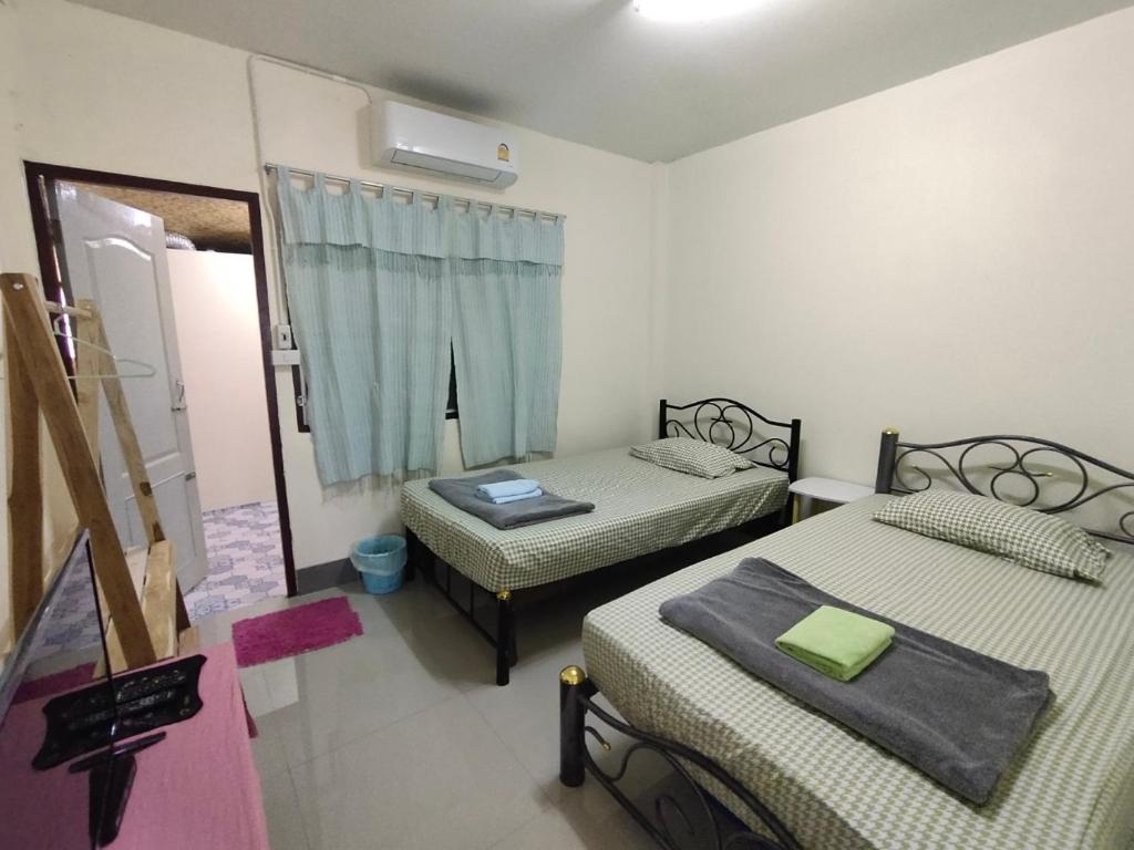 a small room with two beds and a window at ทองอุไรโฮมสเตย์ ณ แม่สาย in Mae Sai