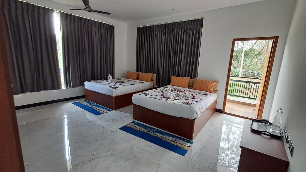 Un dormitorio con dos camas y una ventana en Forest Abode, en Yercaud