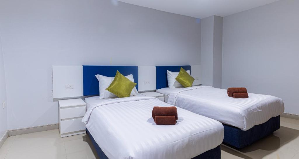 two beds in a room with white and blue at Silla Patong Boutique in Patong Beach