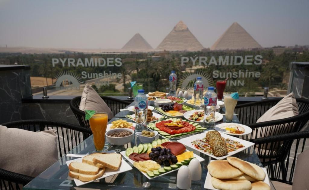 a table topped with plates of food on top of pyramids at Pyramids Sunshine Hotel in Cairo