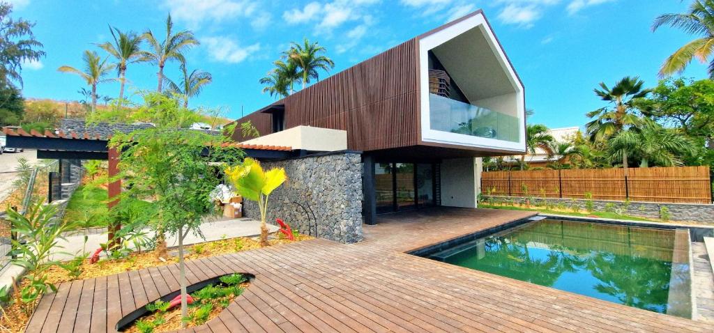 a villa with a swimming pool and a house at Le Domaine des Manguiers in Saint-Gilles les Bains