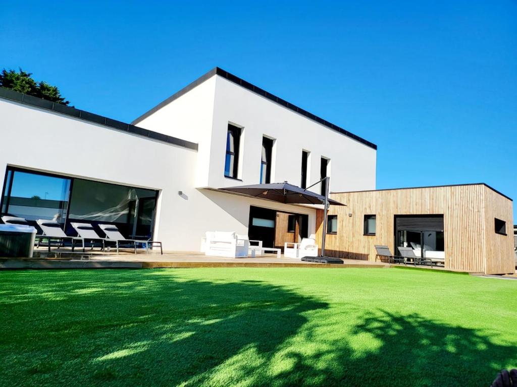 een wit huis met een gazon ervoor bij Villa Ty Billou in Santec