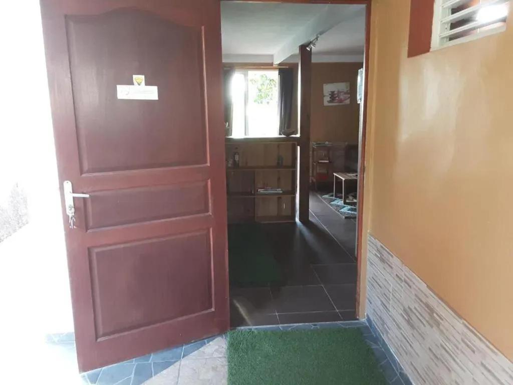 a door leading into a room with a green rug at Bungalow cosy à Capesterre-Belle-Eau avec piscine in Petites Mamelles