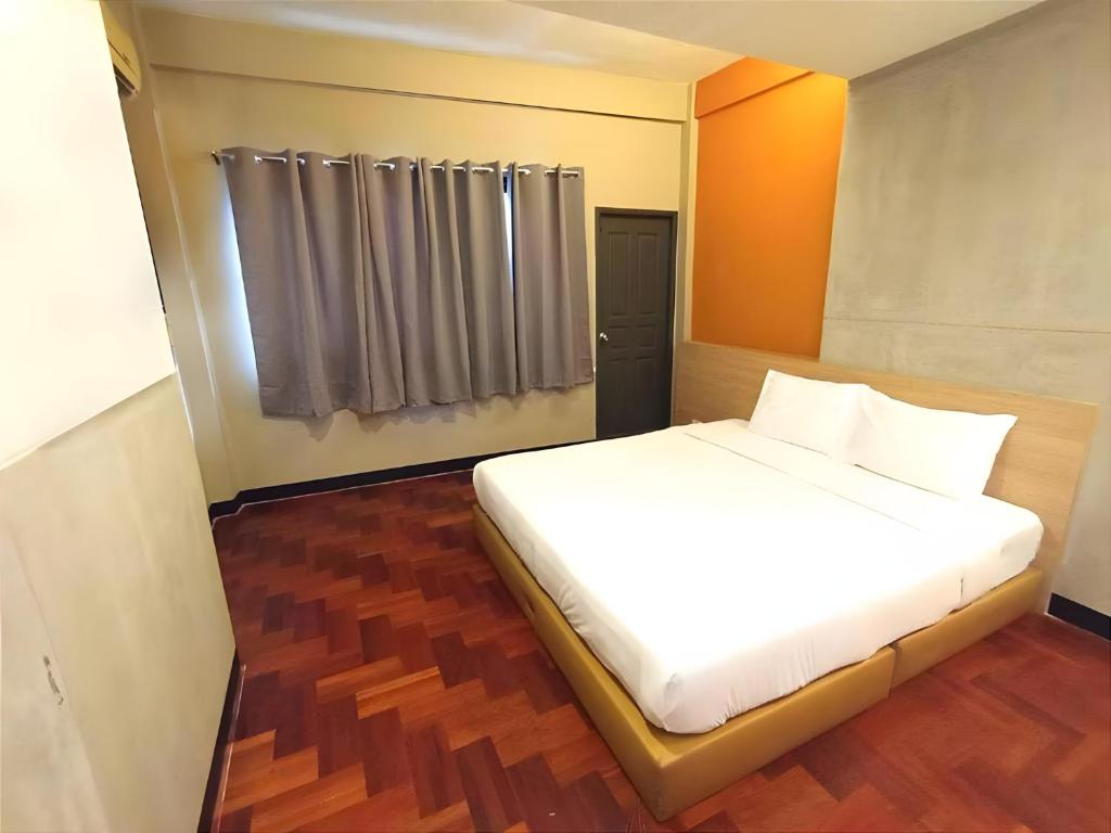 a bedroom with a bed with white sheets and a window at BOB INN Silom - BTS Surasak in Yan Nawa
