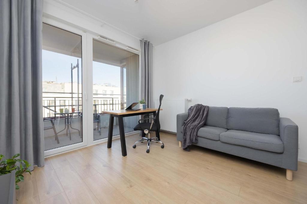 a living room with a couch and a table at Warsaw Elegant Apartment with Parking and Balcony by Noclegi Renters in Warszawa