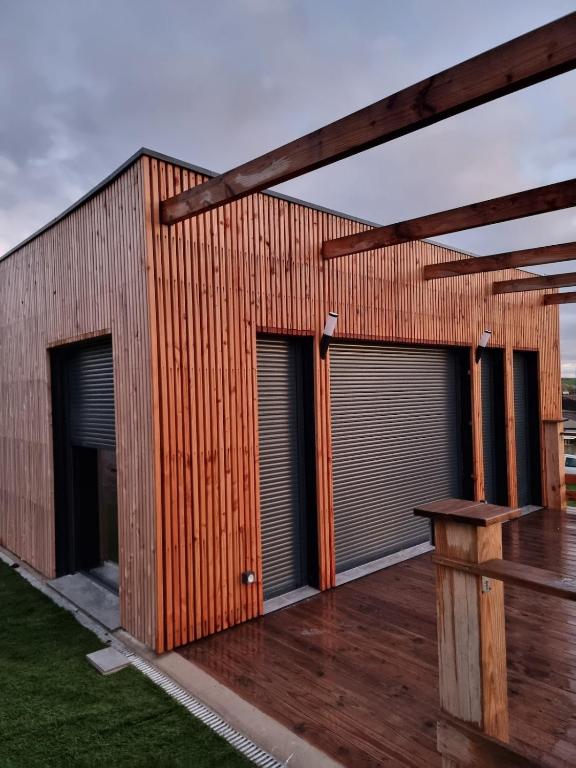 a wooden building with two doors and a deck at Le bêêêl endroit in Gélucourt