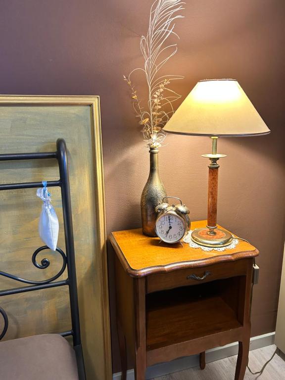 ノットヴィルにあるB&B Friedauのベッド横のテーブルにランプと時計