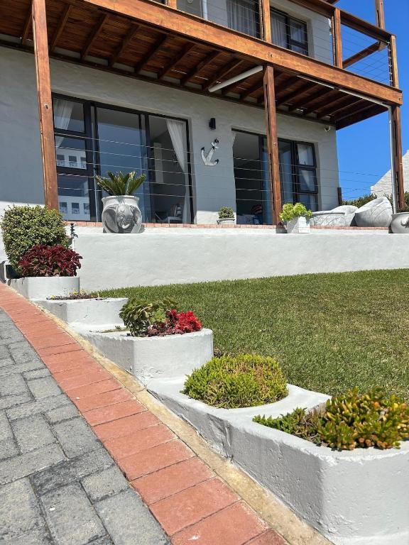 a house with three concrete planters in the grass at Seebossie in Struisbaai