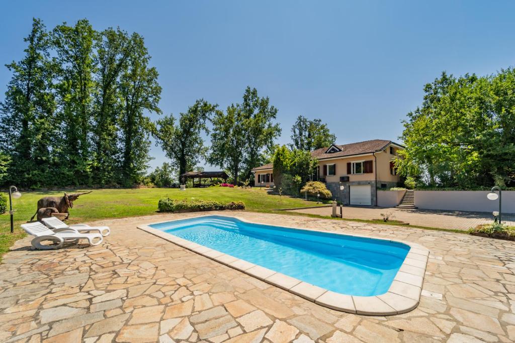 a dog is riding a scooter next to a swimming pool at Villa with Pool in Unesco, 4 Room, Parking e Free WiFi in San Damiano dʼAsti