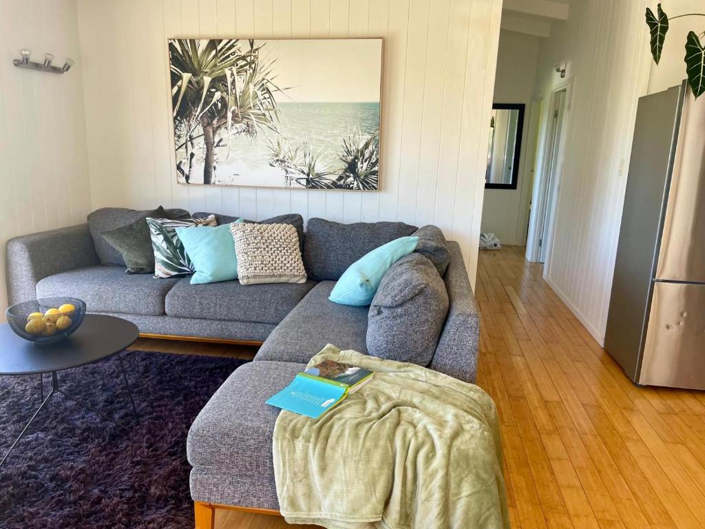 a living room with a couch and a table at Bush & Bay Hideaway in Cable Bay