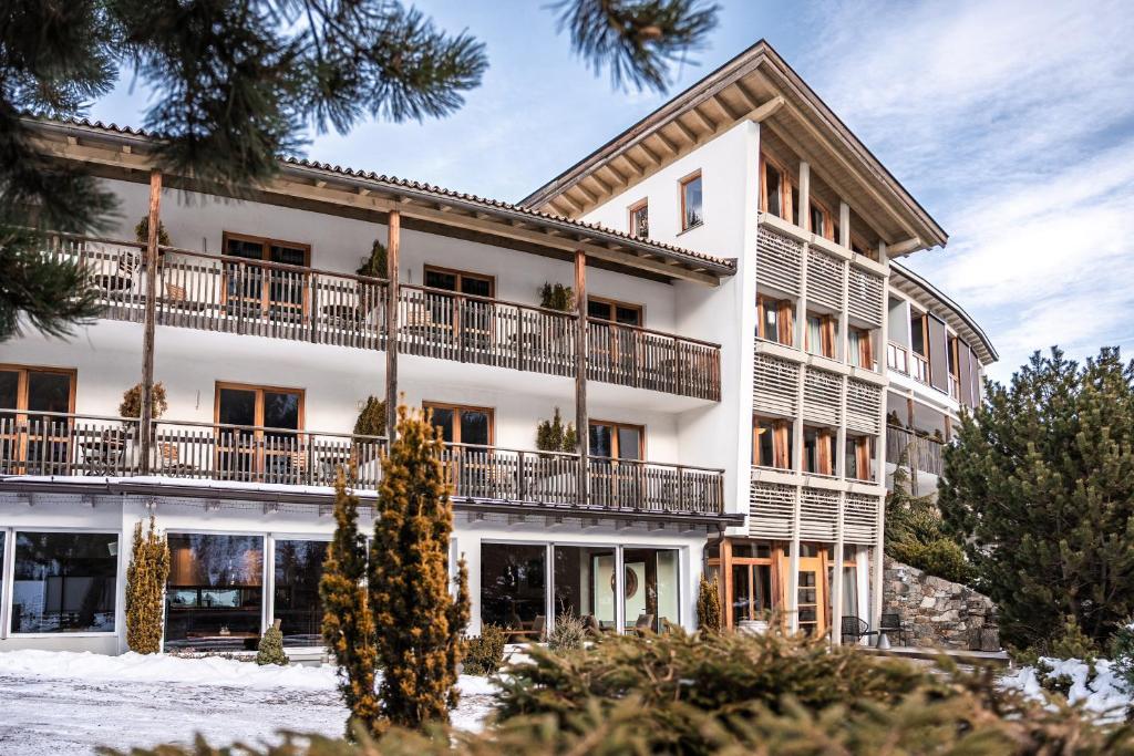 an exterior view of a building with snow at Natur Pur Hotel Unterpichl in Ultimo