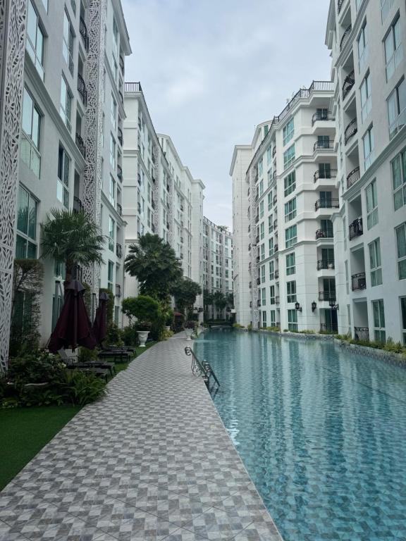 een fiets geparkeerd naast een waterplas met gebouwen bij Olympus City Garden Condo Pattaya High Floor 8F in Ban Nong Chaeng