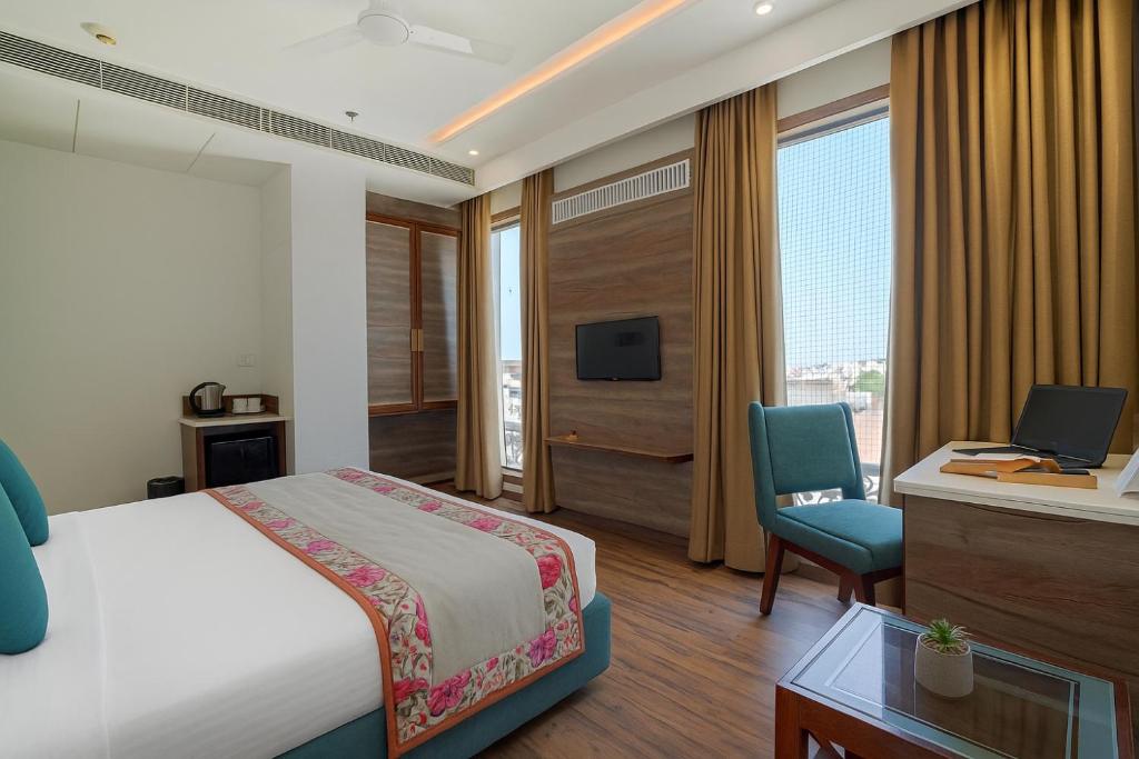 アムリトサルにあるHotel Amrit viewのベッドと机とテレビがあるホテルの部屋