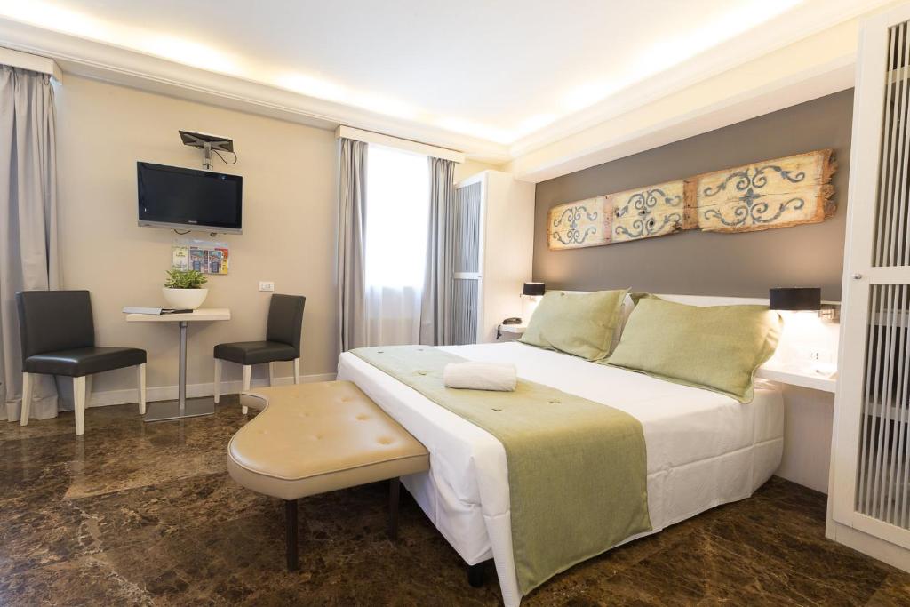 Un dormitorio con una gran cama blanca y un escritorio. en Quintocanto Hotel & Spa, en Palermo
