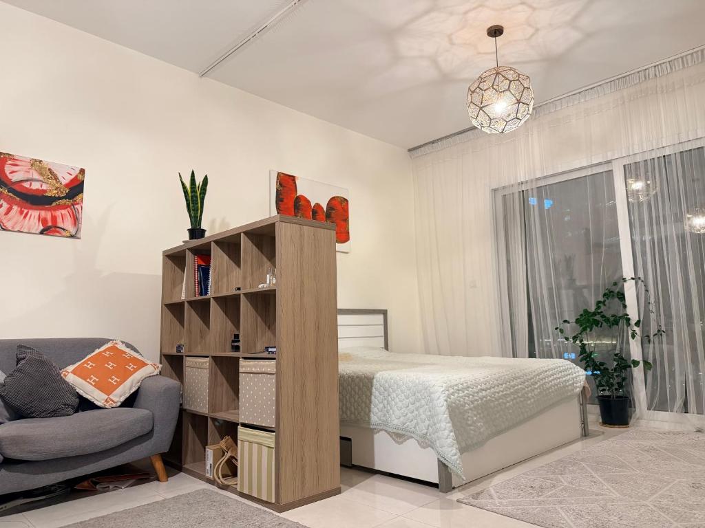 une chambre avec un lit, un canapé et une chaise dans l'établissement Convenient studio in the centre of Dubai, à Dubaï