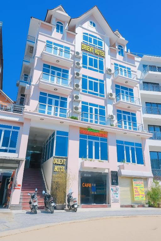 a white building with motorcycles parked in front of it at Orient Tam Đảo Hotel in Tam Ðảo