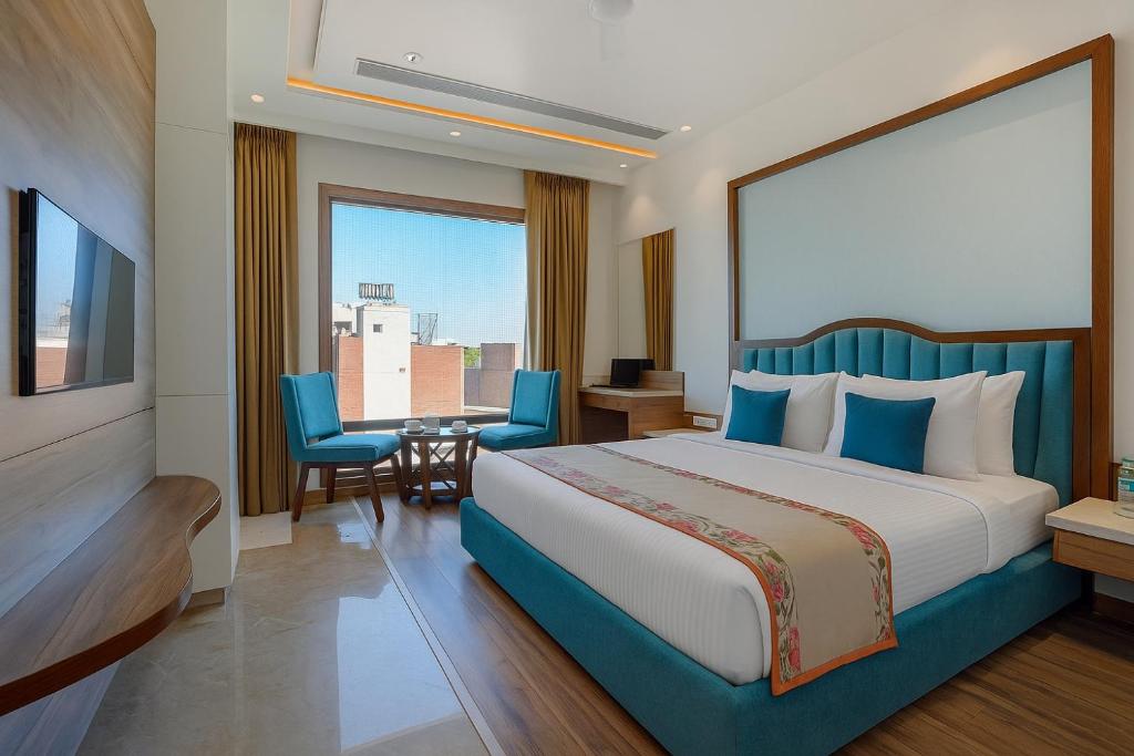 um quarto de hotel com uma cama, uma mesa e cadeiras em Hotel Comfort view em Amritsar
