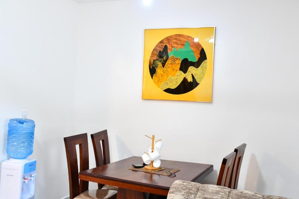 a dining room table and chairs with a painting on the wall at Buxton Point Mombasa in Mombasa