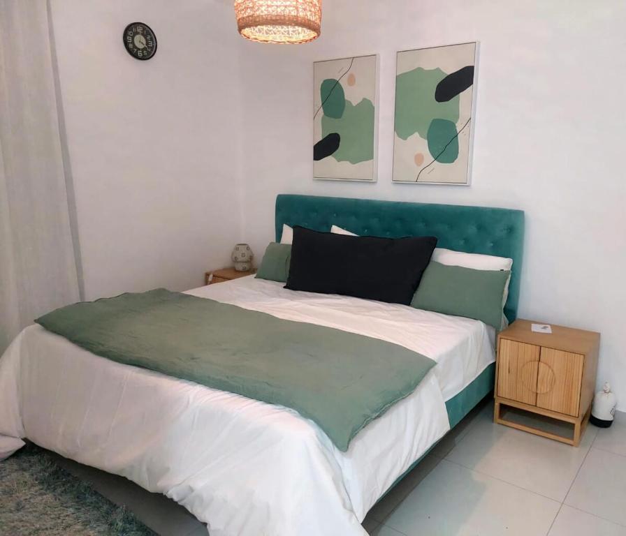 a bed with a green headboard in a bedroom at So Chic Family Villa in Flic-en-Flac