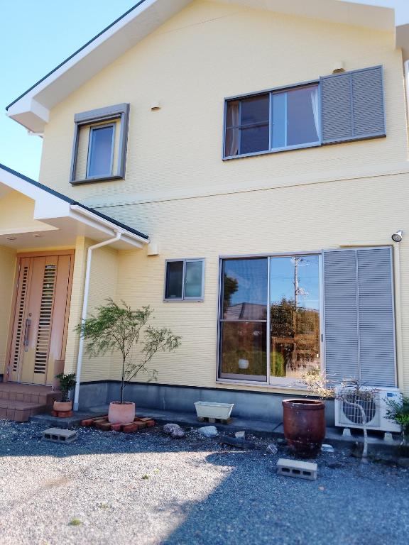a house with windows and plants in front of it at 小さなペンション Branchee in Kushimoto