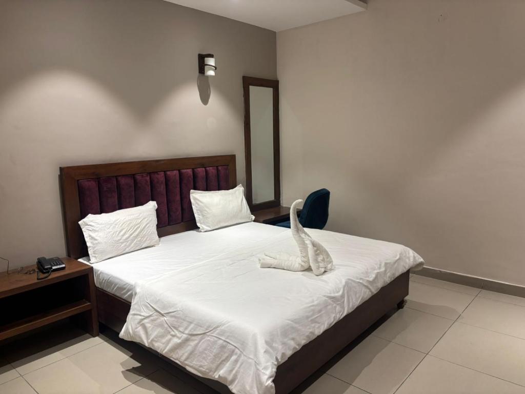 a bedroom with a bed with a stuffed animal on it at Hotel Maria in Dera Bassi