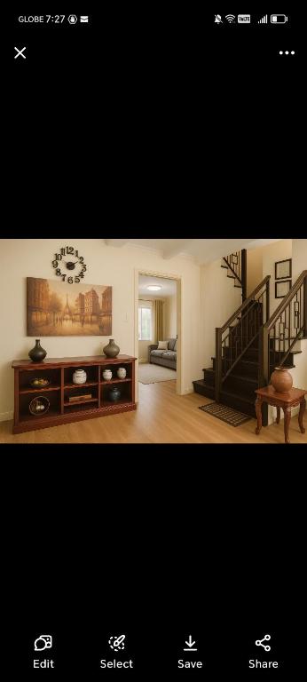 a living room with a staircase and a living room with a table at David home in Manila