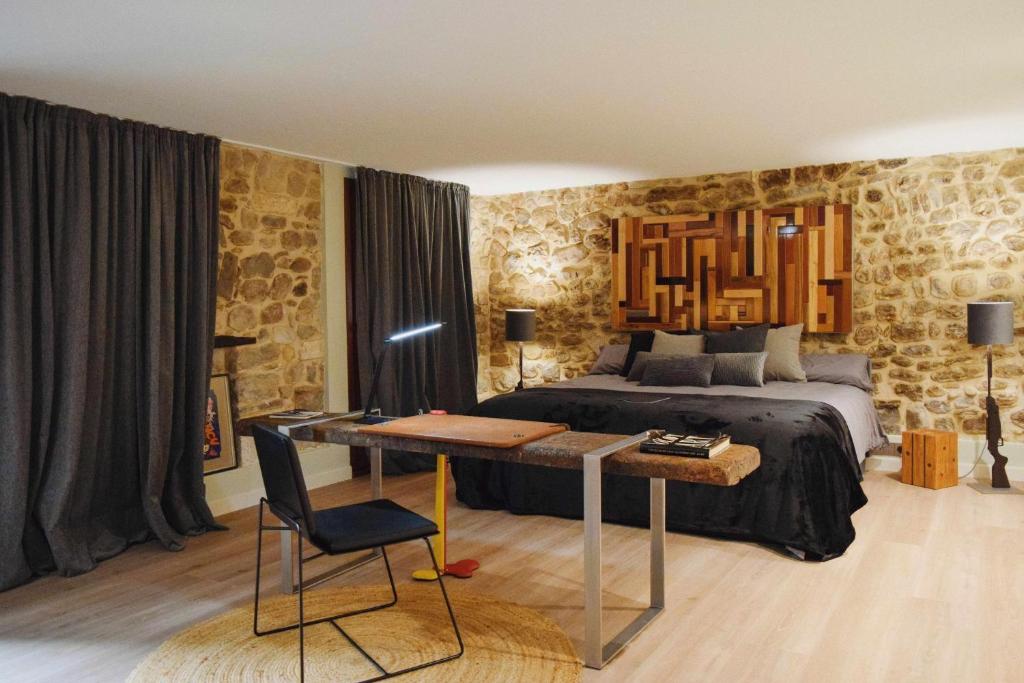 a bedroom with a bed and a desk with a desk at Kel Domènech Luxury Apartment in Besalú