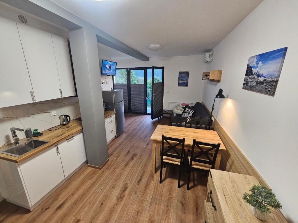 eine Küche und ein Wohnzimmer mit Tisch und Stühlen in der Unterkunft Komfortowy, klimatyzowany apartament Góry Marzeń - Lesko in Lesko