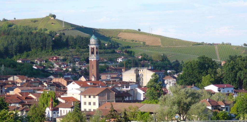 a town with a clock tower in the middle of a town at Casa del gelso in Canale