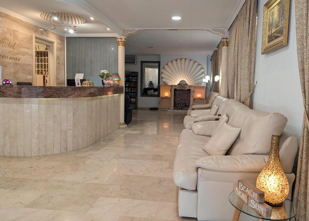 a living room with white couches and a bar at Hotel Medium Claramar in Platja  d'Aro