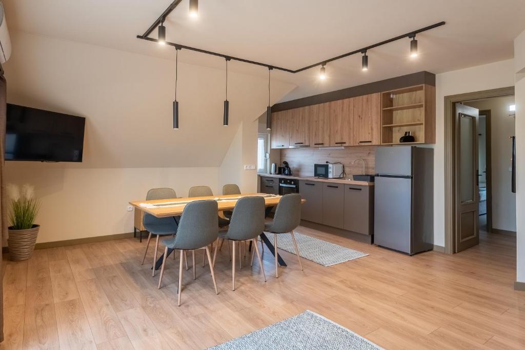 a kitchen and dining room with a table and chairs at Trio Relax Apartmanok in Kiskunmajsa