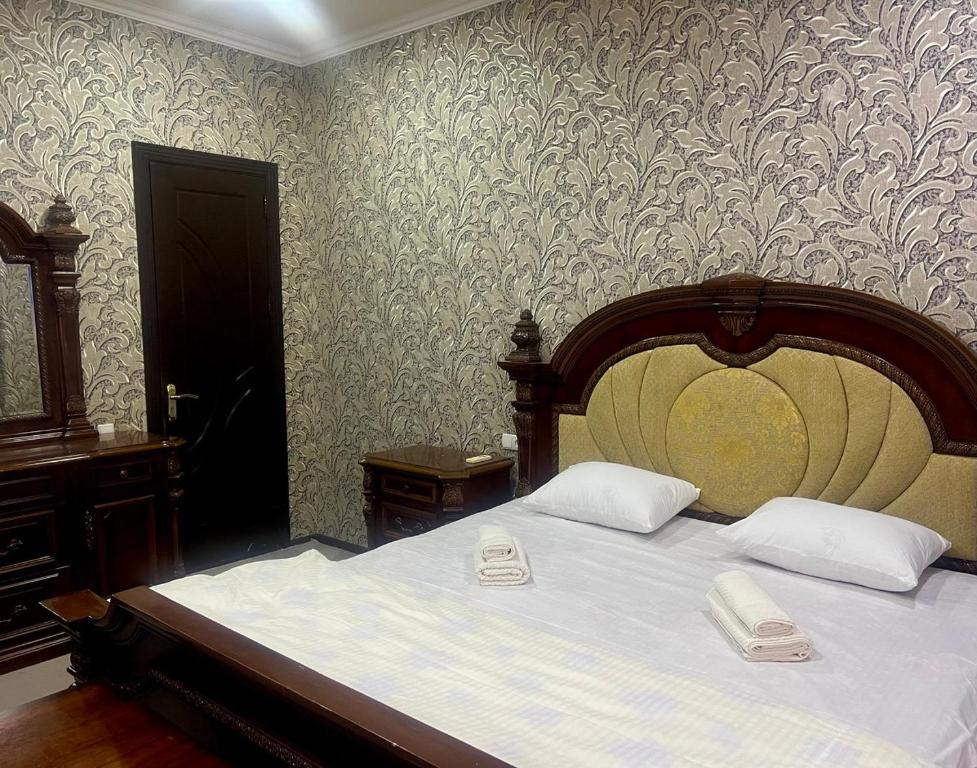 a bedroom with a large bed with two phones on it at Hostel Marshal in Termiz