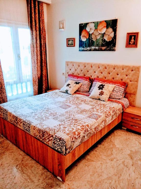 a bedroom with a bed with pillows and a window at Cléopâtre appartement in Hammam Sousse