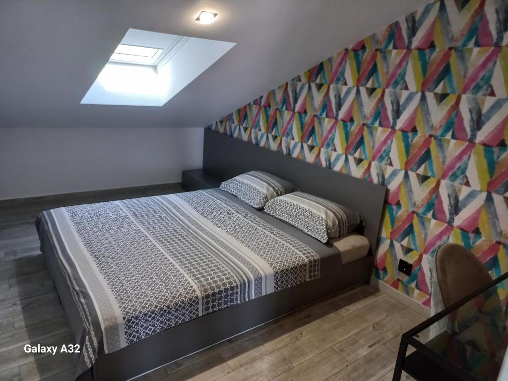 a bedroom with a bed with a mosaic wall at New Grey in Novi Beograd