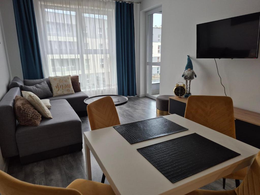a living room with a couch and a table at Apartament BALTIC in Koszalin
