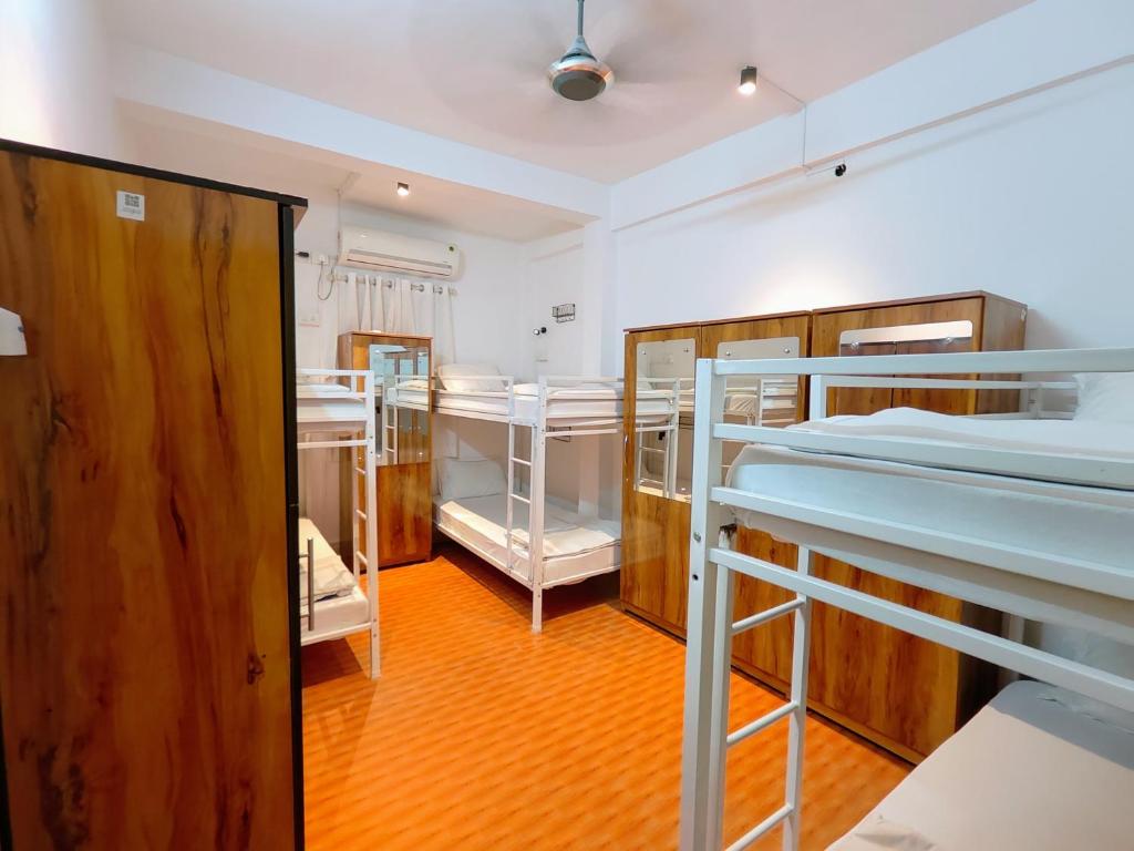 Una habitación con tres literas y un pasillo. en HOSHTEL99 - PRIME - Stay, Cowork & Connect, en Pune