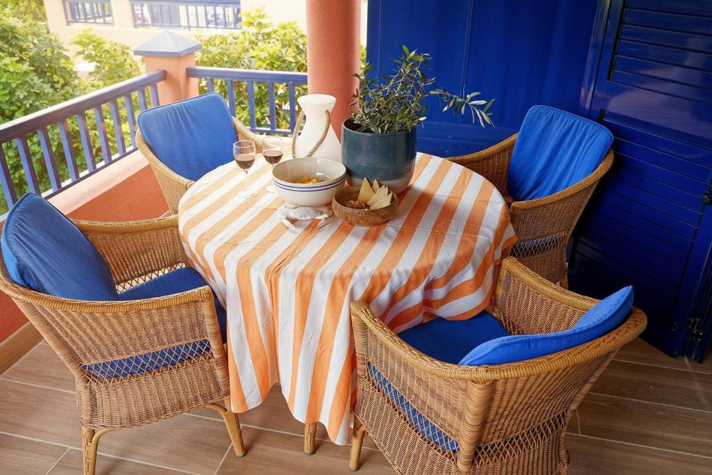 a table with chairs and a bowl of food on a porch at Villa Flamboyán Meloneras in Meloneras