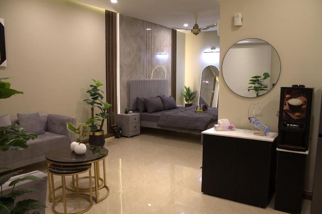 a living room with a couch and a mirror at Spacious Studio with UPS, across Giga mall, Pool included in Islamabad