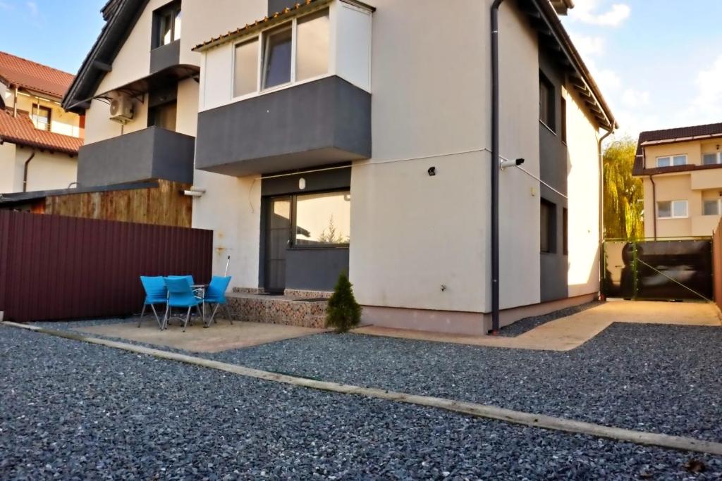 uma casa com duas cadeiras azuis em frente em FLH - MIG Loft Sibiu em Cisnădie
